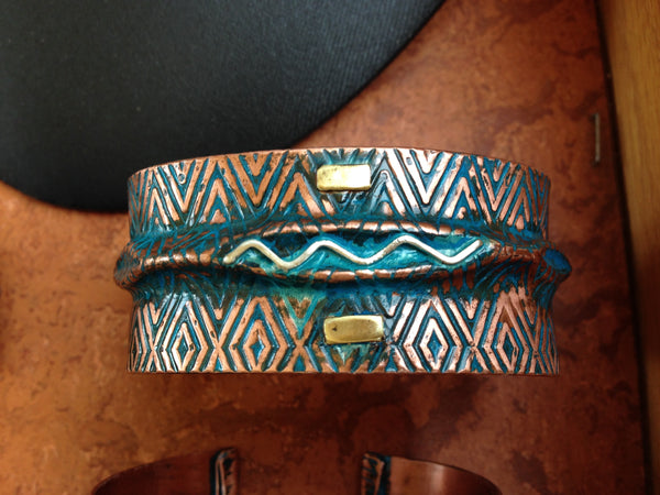 wide folded copper bracelet with embossed zigzag pattern, blue-green patina, silver wave and brass accents.
