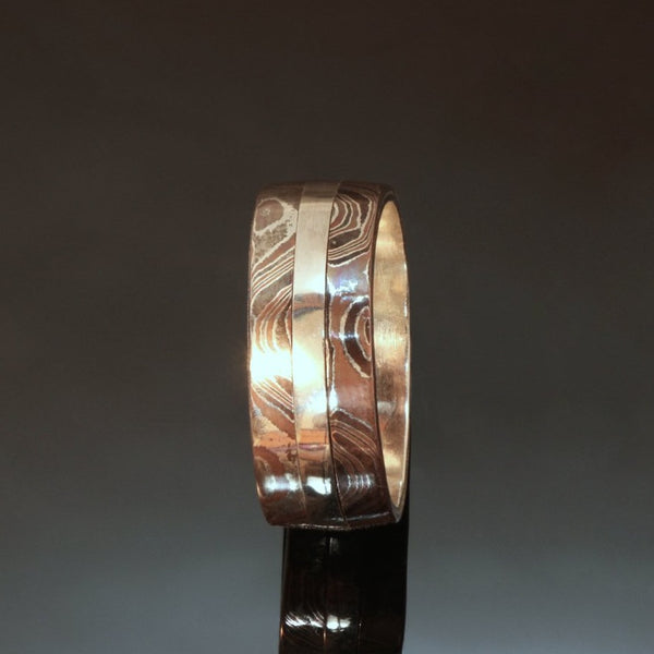 8mm wide Silver band with a centre stripe of Sterling silver and a band of mokume gane on the outside edges.