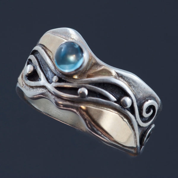 silver and gold ring with waves, black patina and blue topaz cabochon