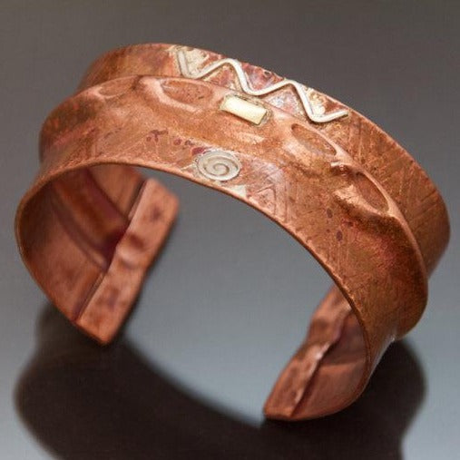 folded copper bracelet with zigzag pattern embossed, silver wave and disc with red patina