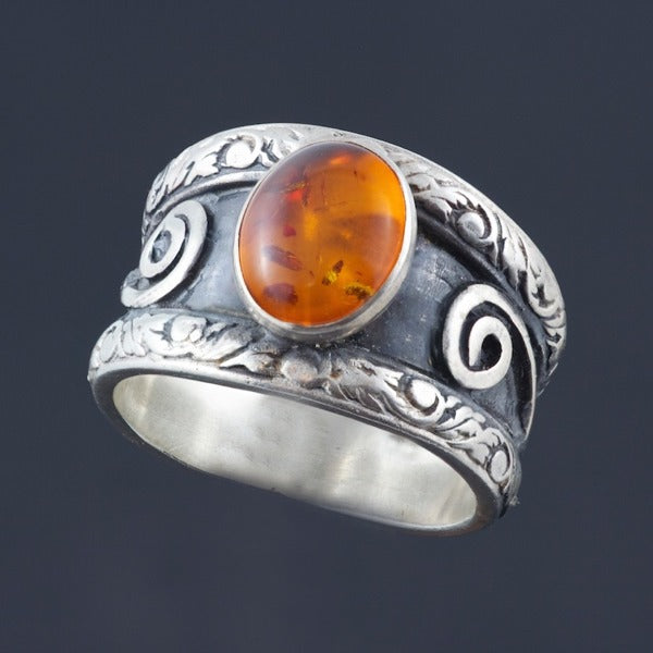 double band silver ring with oval amber with recessed parts oxidized.