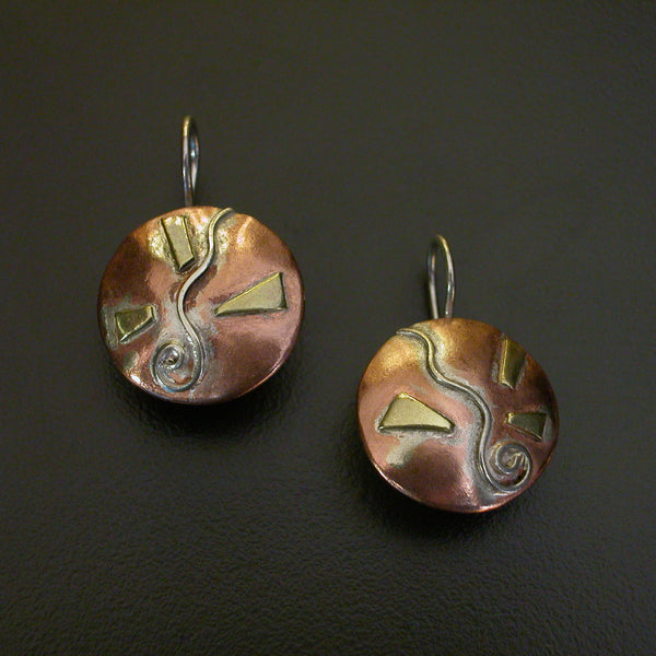 round natural copper coloured earrings with silver spiral and wave and brass