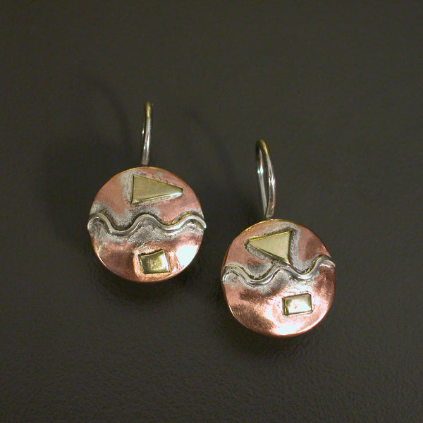 round natural copper coloured earrings with horizontal silver wave and brass