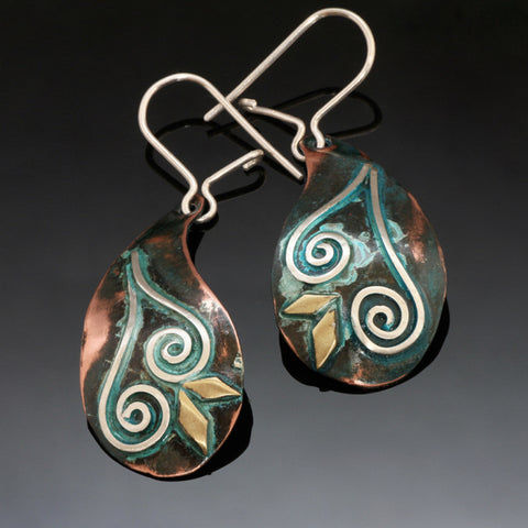 Teardrop shaped copper earring with a spiral design and blue/green patina