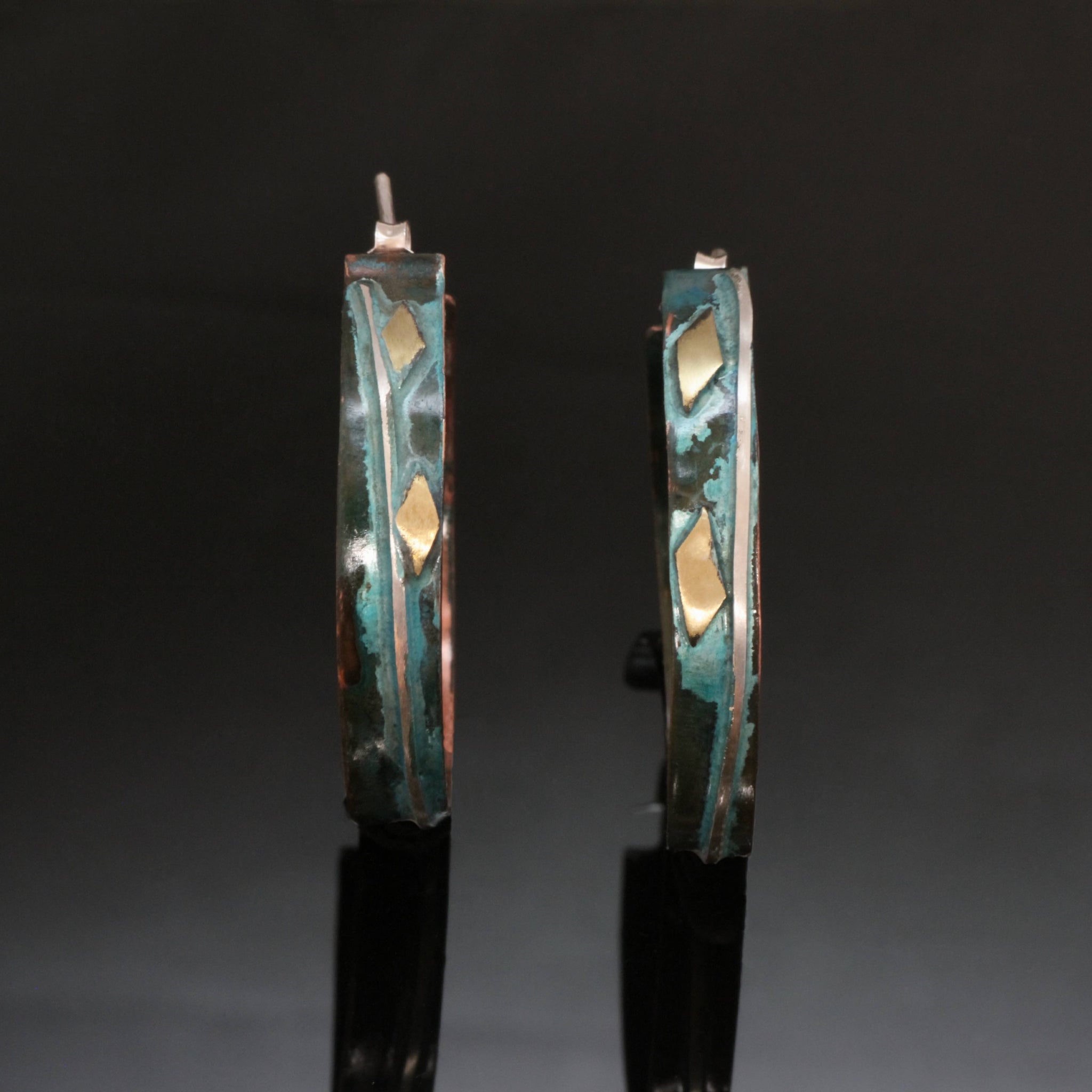 narrow copper hoops with a line of silver wire, brass accents and blue/green patina.