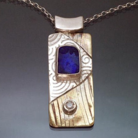  long rectangular silver brass necklace with blue beach glass and cubic zirconia, spirals embossed into the silver.