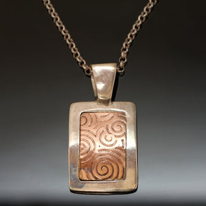 Silver gold necklace with spirals embossed and long bale.