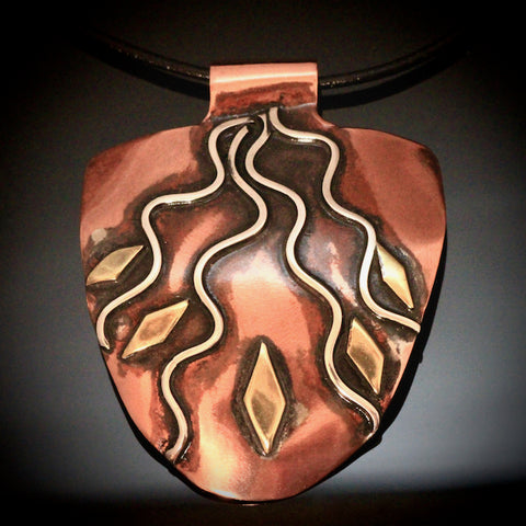 half round copper pendant with silver rays streaming down, black patina and brass accents