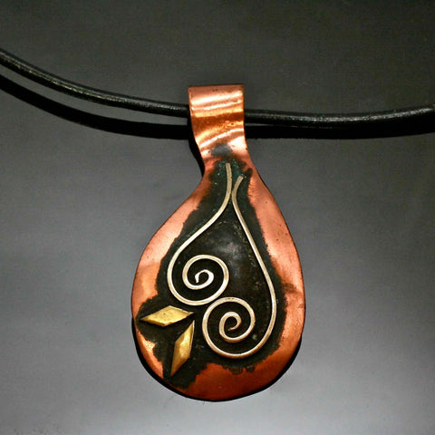 copper necklace with black patina, silver spirals and brass accents on a leather band