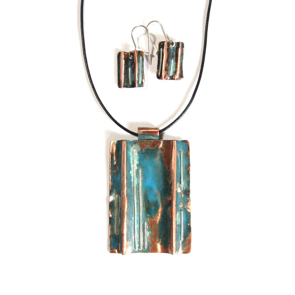 folded copper necklace with patina, straight lines of silver on a leather band with matching earrings.