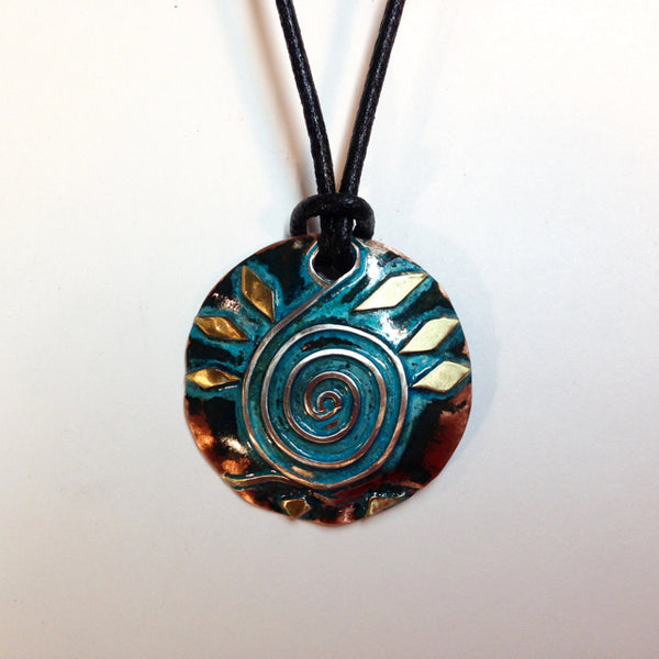 round copper necklace with blue/green patina, silver wave and spiral shaped like a clavicle, brass accents on a leather band