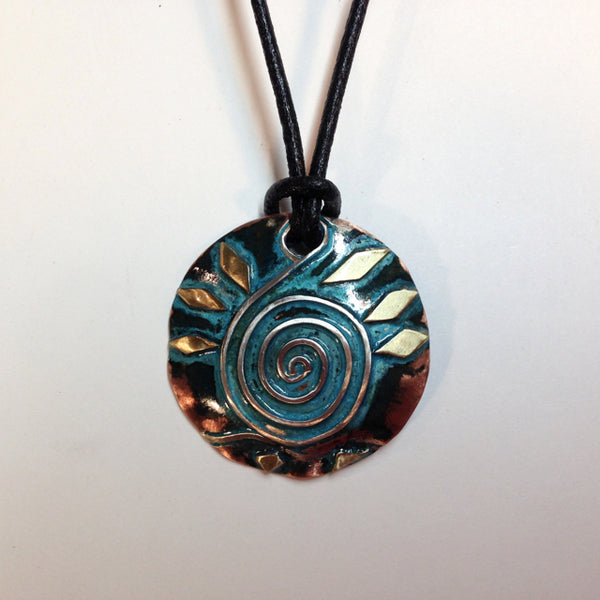 round copper necklace with blue/green patina, silver wave and spiral shaped like a clavicle, brass accents on a leather band