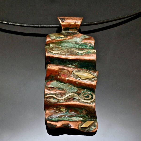 folded copper necklace with patina, silver wave, spirals and brass accents on a leather band