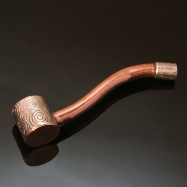 small bent copper pipe with a silver bowl embossed with spirals