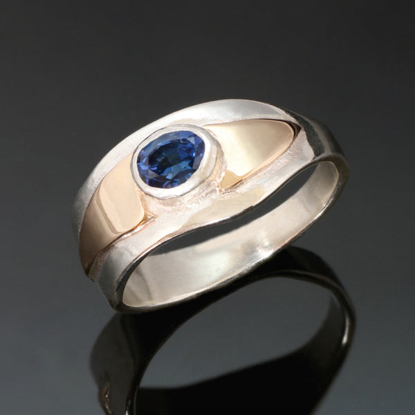 14k yellow gold ring with wavy edges, raised gold around the oval blue sapphire.