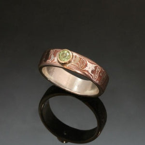 mokume ring with sterling silver, a faceted peridot set into gold bezel.
