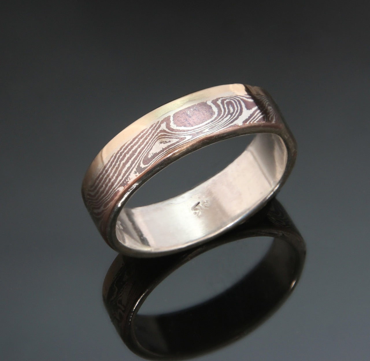 narrow mokume ring with a stripe of 10k gold on one edge