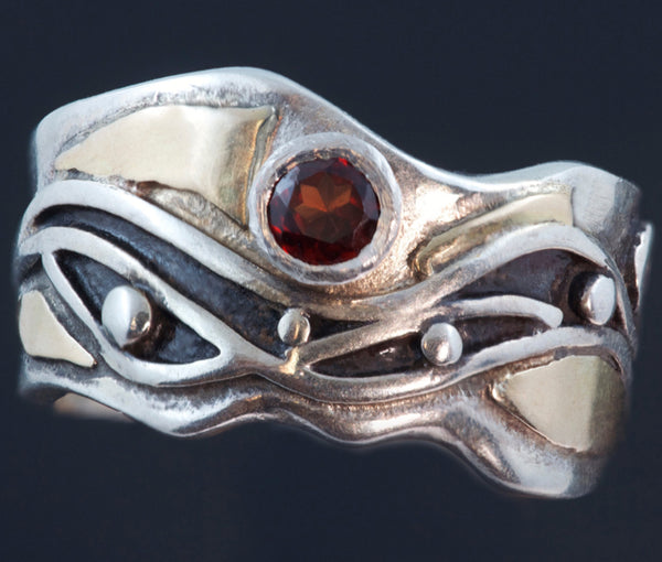silver and gold ring with waves, black patina and faceted garnet