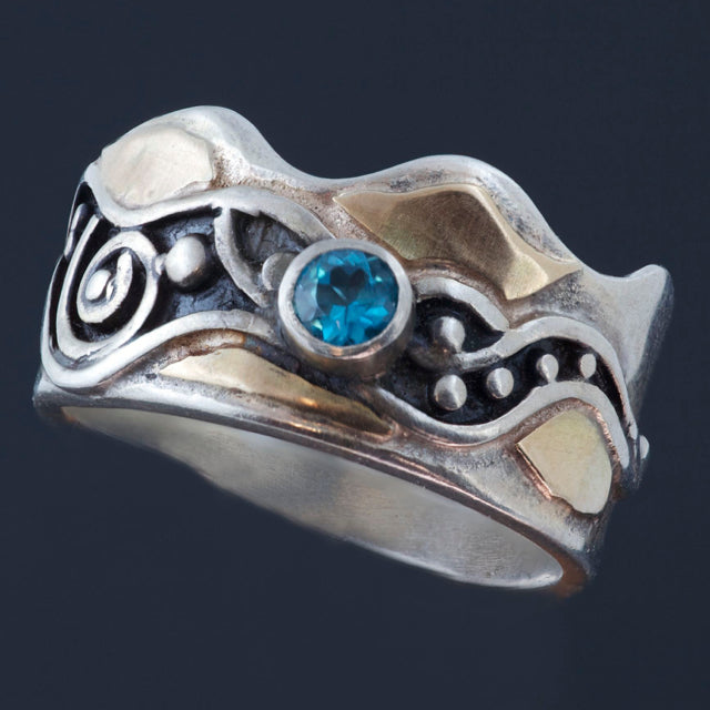 Blue topaz silver ring with gold accents and patina in recessed parts