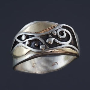 silver ring with waves, spiral and dots oxidized black and yellow gold accents around the pattern.