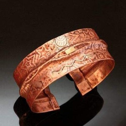 folded copper bracelet with stars embossed, silver wave and disc with red patina