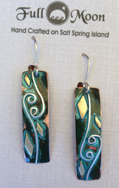 long rectangular copper earrings with 2 spirals and waves, brass accents and blue/green patina.